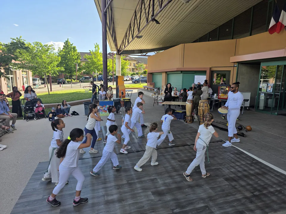 Des enfants pratiquent la ginga en plein air avec leur professeur à Crolles.