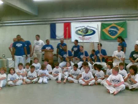 Niños sentados frente a los músicos y los instrumentos del batizado 2009 en Grenoble.