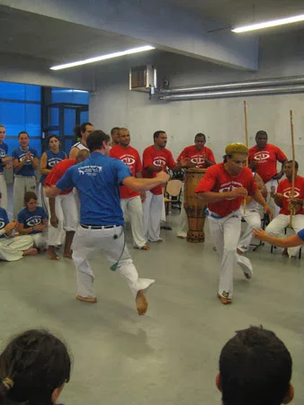 Two participants in blue and red T-shirts playing in the centre of the roda.